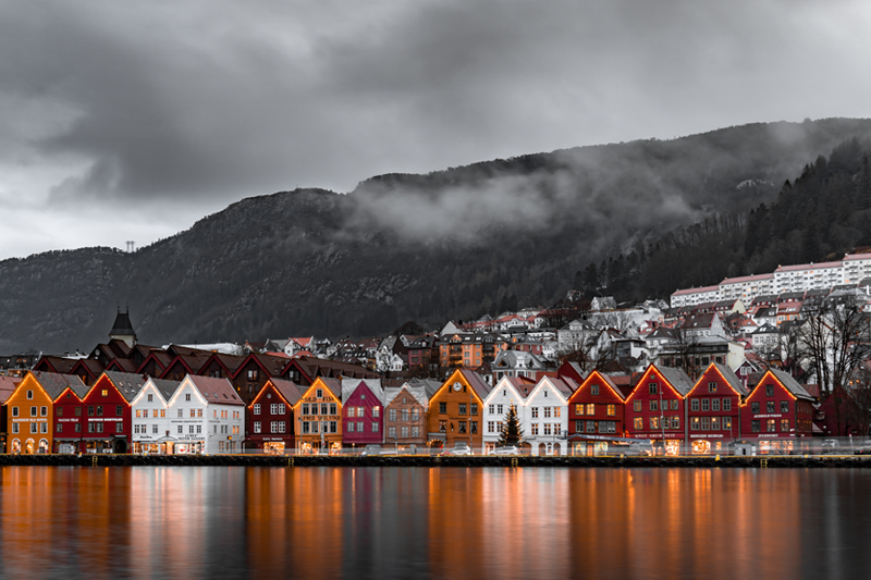 Lake houses in Norway, with a misty mountain in the background