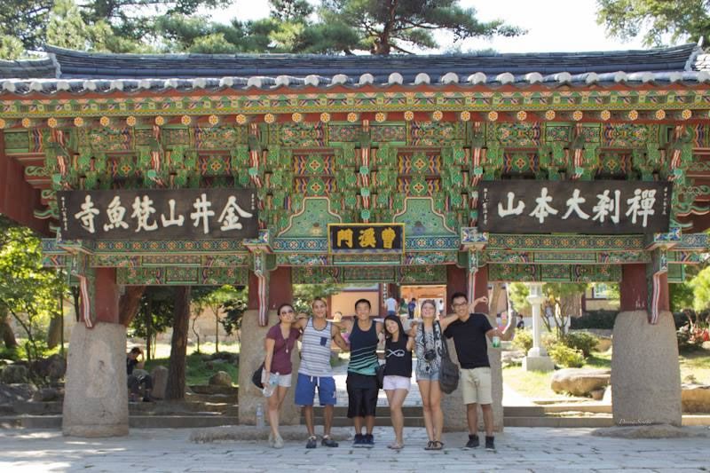 Students pose in front of a brightly colored shrine in South Kore