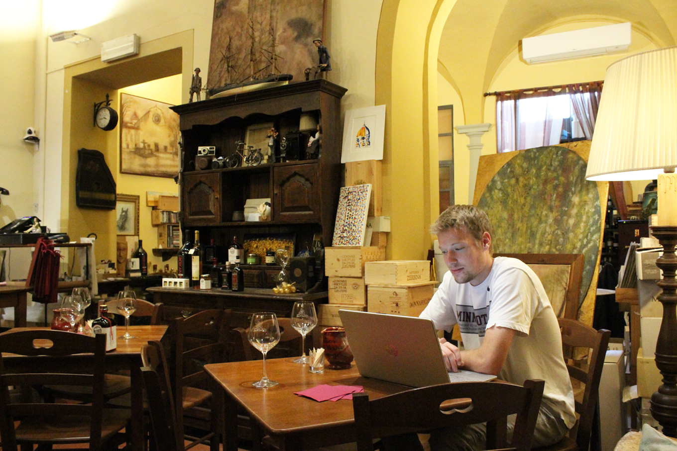 A student works on his laptop in a wine shop in Florence, Italy