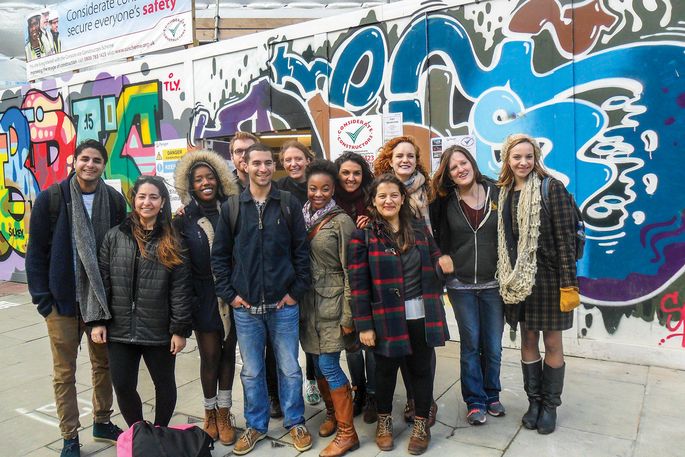 students in front of graffitied wall