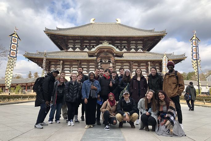 A group of students in front of a Japanese temple