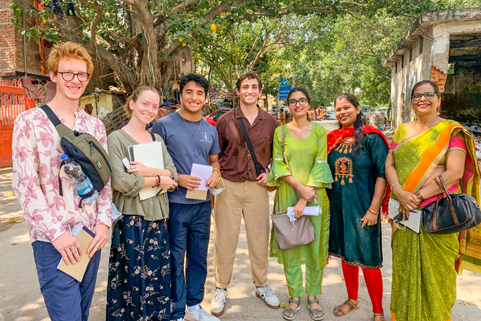 Students and local Indians pose for a photo in India