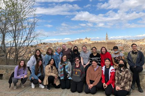 A group of student spose for a photo in front of the Toledo skyline.