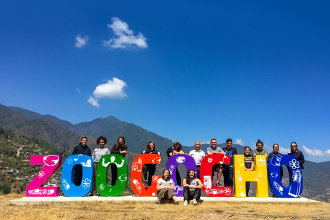 A group of students pose for a photo behind bright, giant letters that spell "ZOOGOCHO"