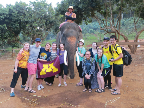 Students pose in front of an elephant